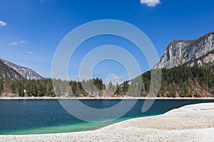 Blue sky is reflected in the emerald mineralised water of Tovel lake high in the mountains,Â Ville d`Anaunia, Trentino, Italy
